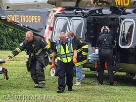 CALS crew member assisting members from Dunkirk VFD with loading the patient into the helicopter.